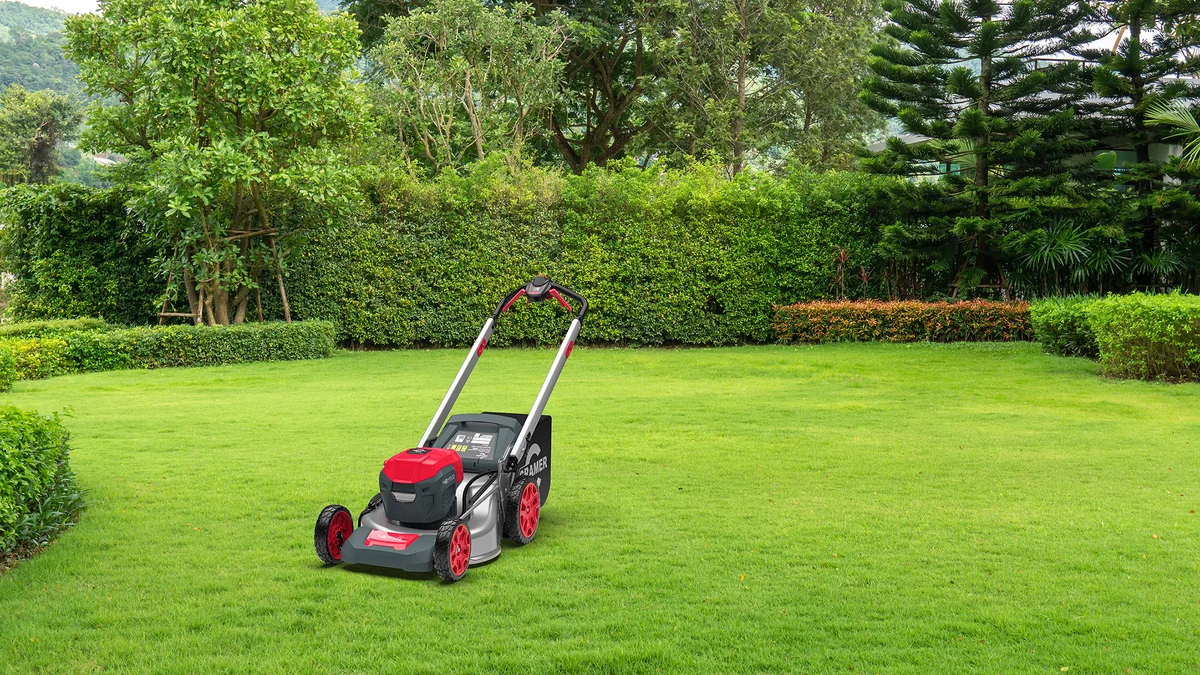 Tondeuse autopropulsée Cramer 48LM51 rouge et grise en action sur une pelouse verte bien entretenue